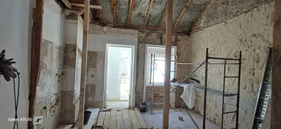 Interior da moradia com nova caixilharia e paredes preparadas para acabamento.