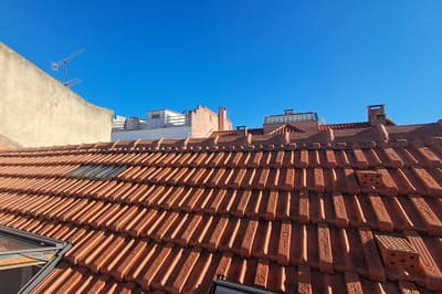 Cobertura da moradia na Travessa do Olival após a substituição da estrutura, com telha nova assente e janelas de sótão instaladas.