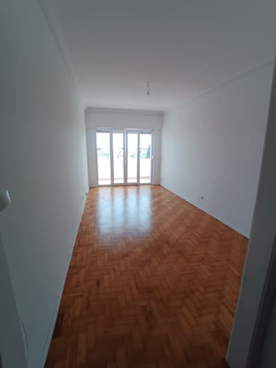 Quarto do apartamento com soalho em madeira envernizado e janela nova.
