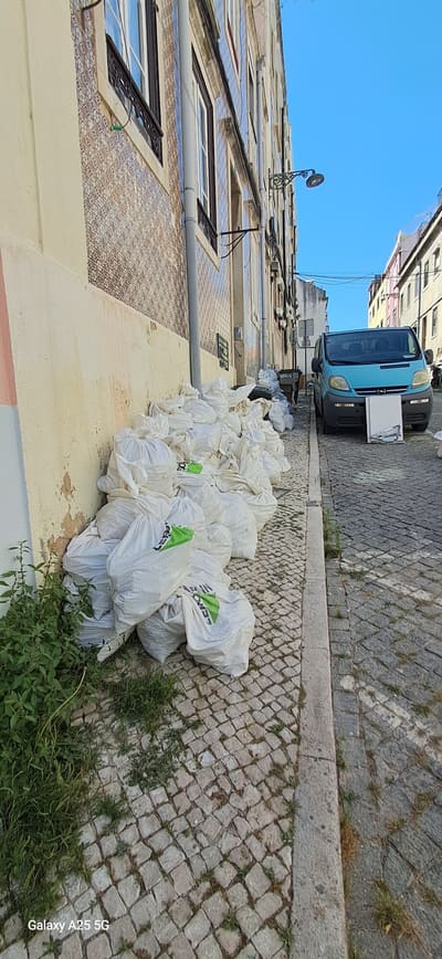 Travessa do Olival, com a fachada da moradia em obra e a rua em calçada.