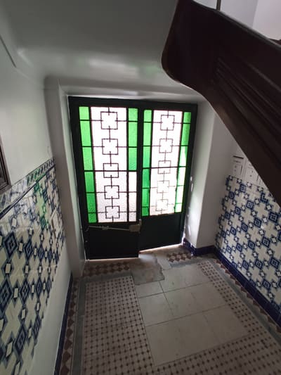 Detalhe de azulejo azul e branco de padrão recuperado numa parede do prédio.