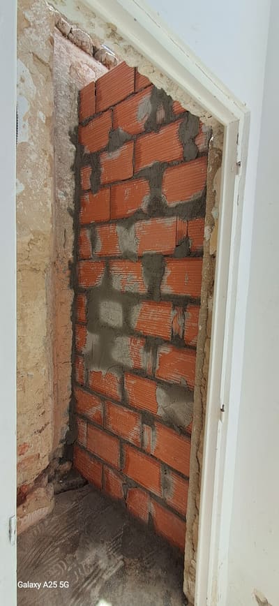 Parede em alvenaria de tijolo refeita durante a remodelação estrutural.